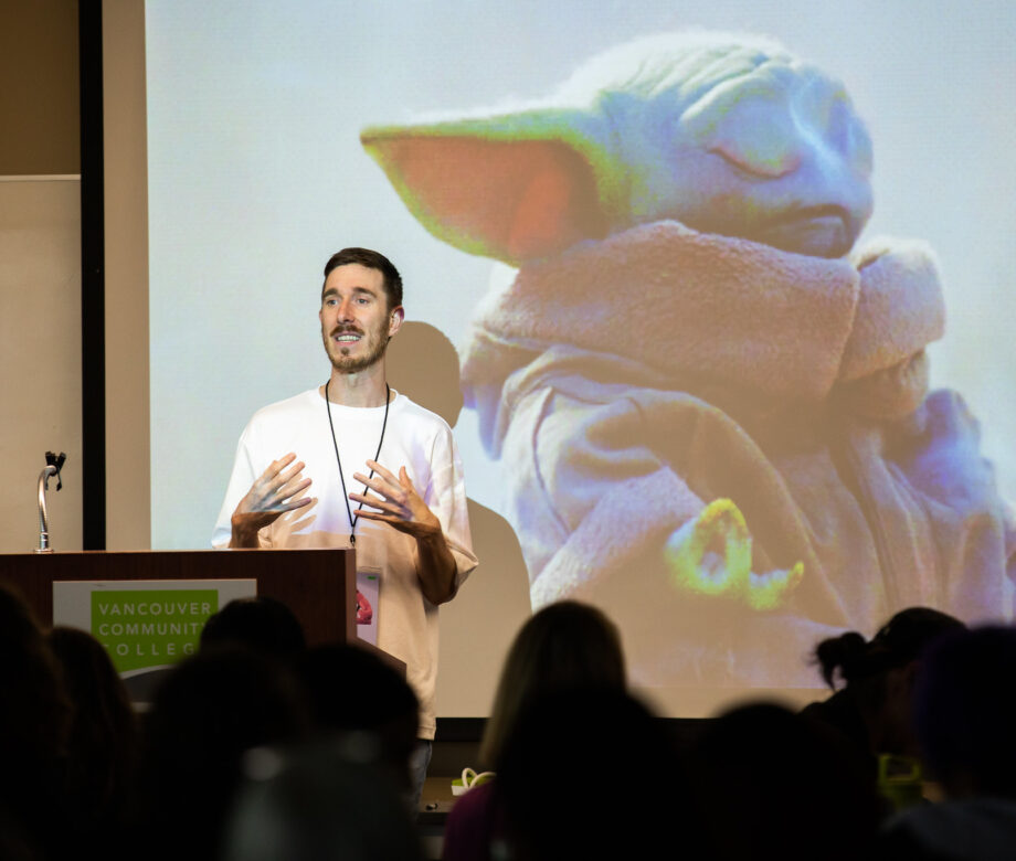 Dominic Prevost leading a workshop. A photo of baby Yoda is on the screen behind him.