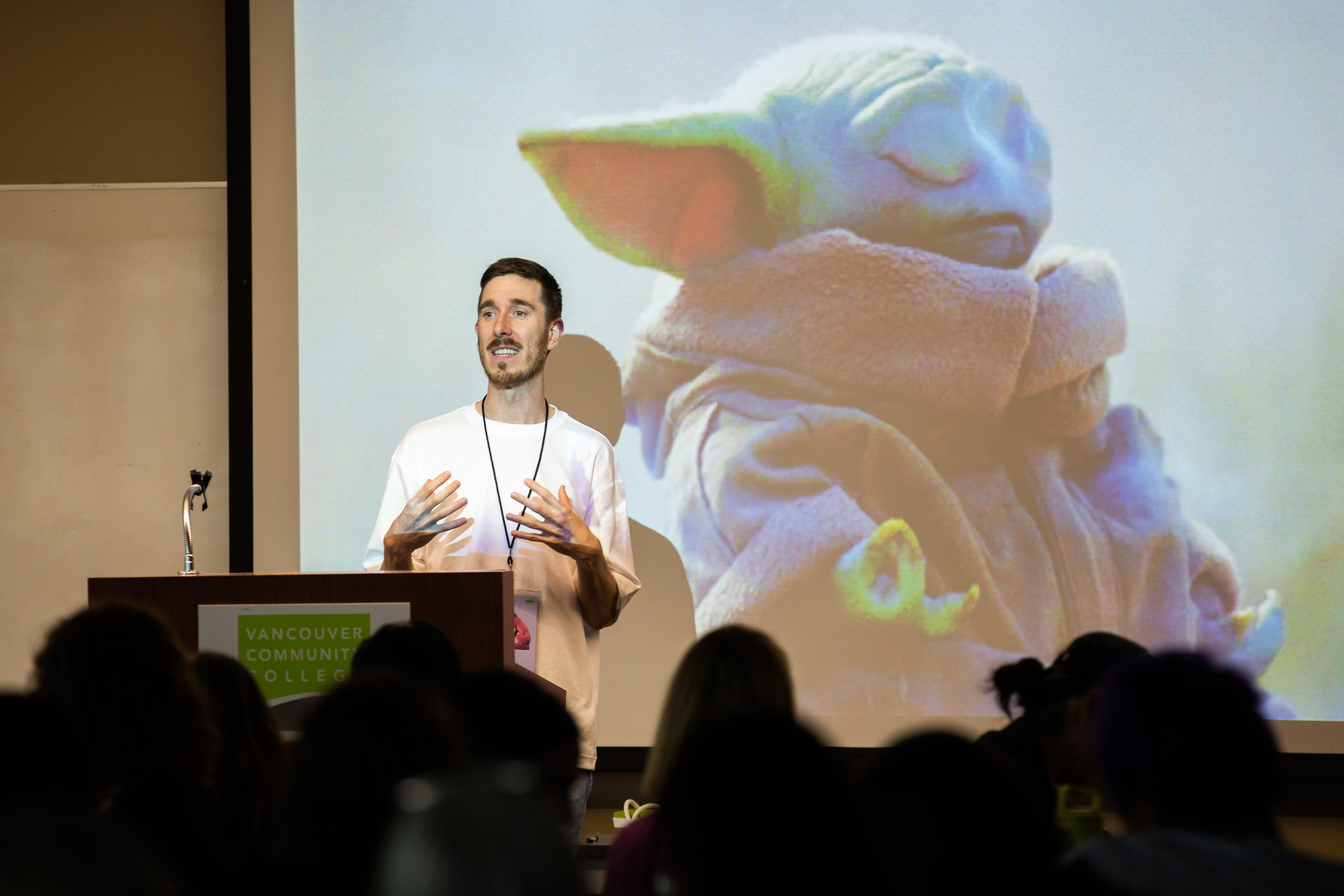 Dominic Prevost leading a workshop. A photo of baby Yoda is on the screen behind him.